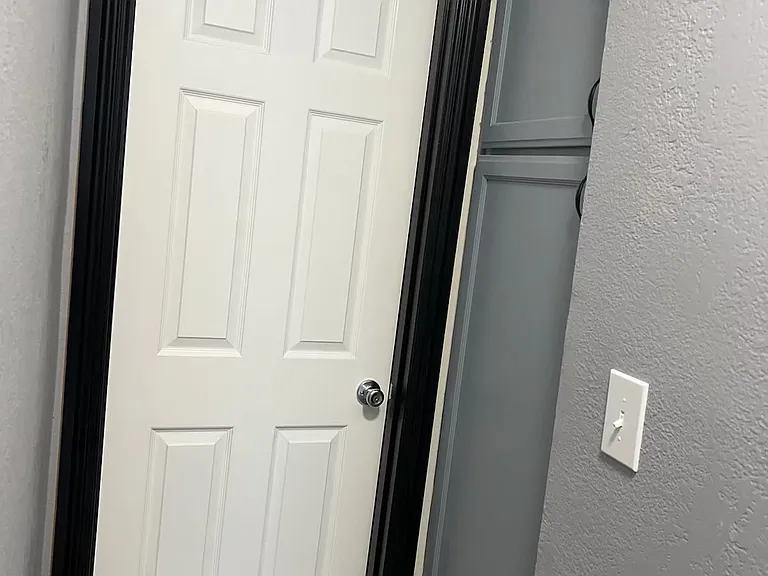 Bathroom entrance and storage cabinets on the right side.