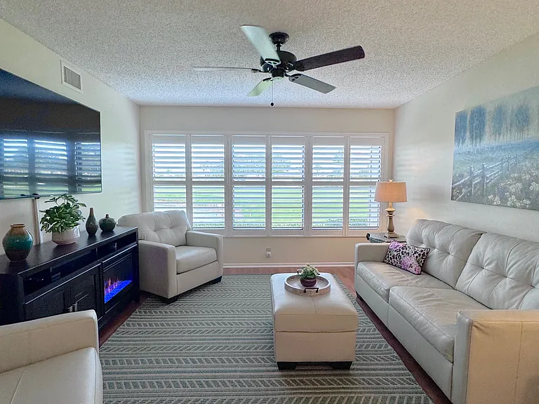 Beautiful living area w/ plantation shutters & gorgeous lake & golf course views!