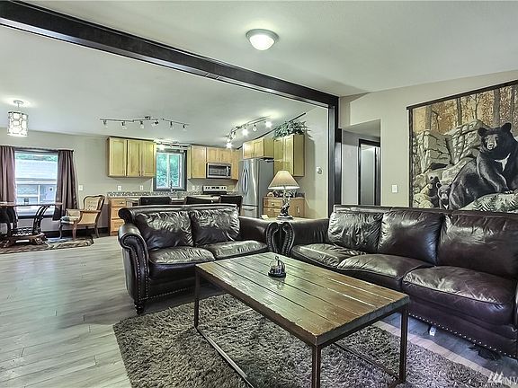 View from living room to dining and kitchen, all open concept with cathedral ceilings and lots of windows. 