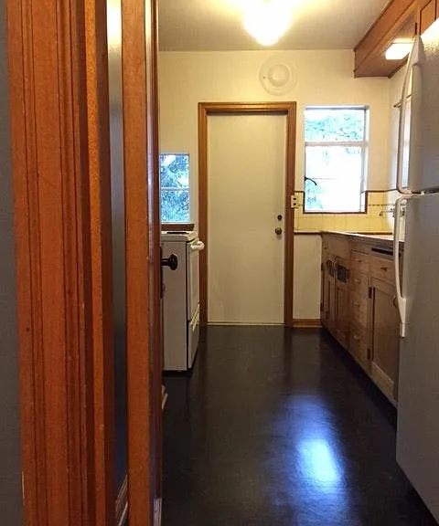 Galley kitchen with generous counter and cabinet space. Back door leads to porch and backyard.