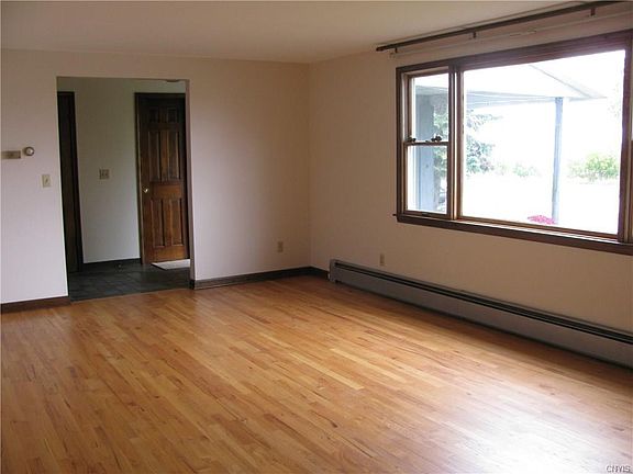 Oversized living room with hardwoods. Large windows look out onto Onondaga Lake