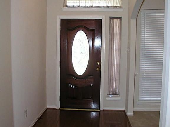 Wood floor entry and crown molding accent the foyer.