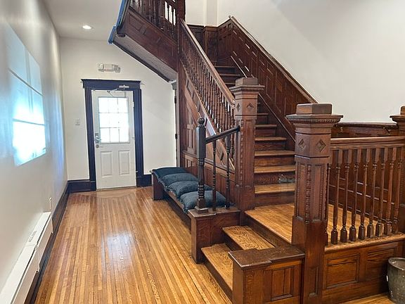 HALLWAY: Beautifully restored hallway and historic staircase. Back door that leads to the private parking lot.
