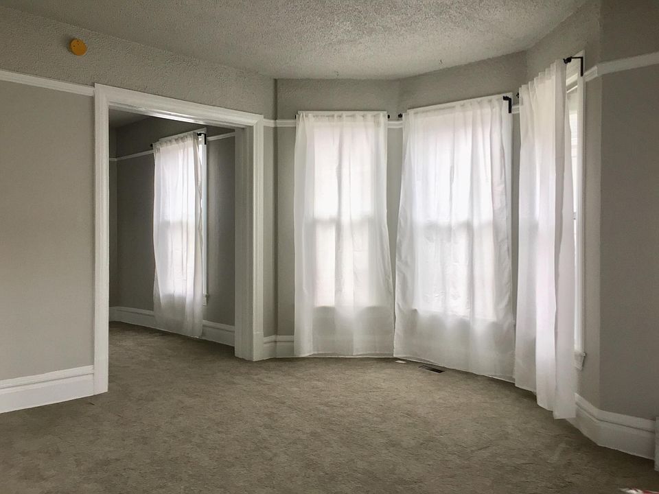 Main living room with bay windows, dining room beyond