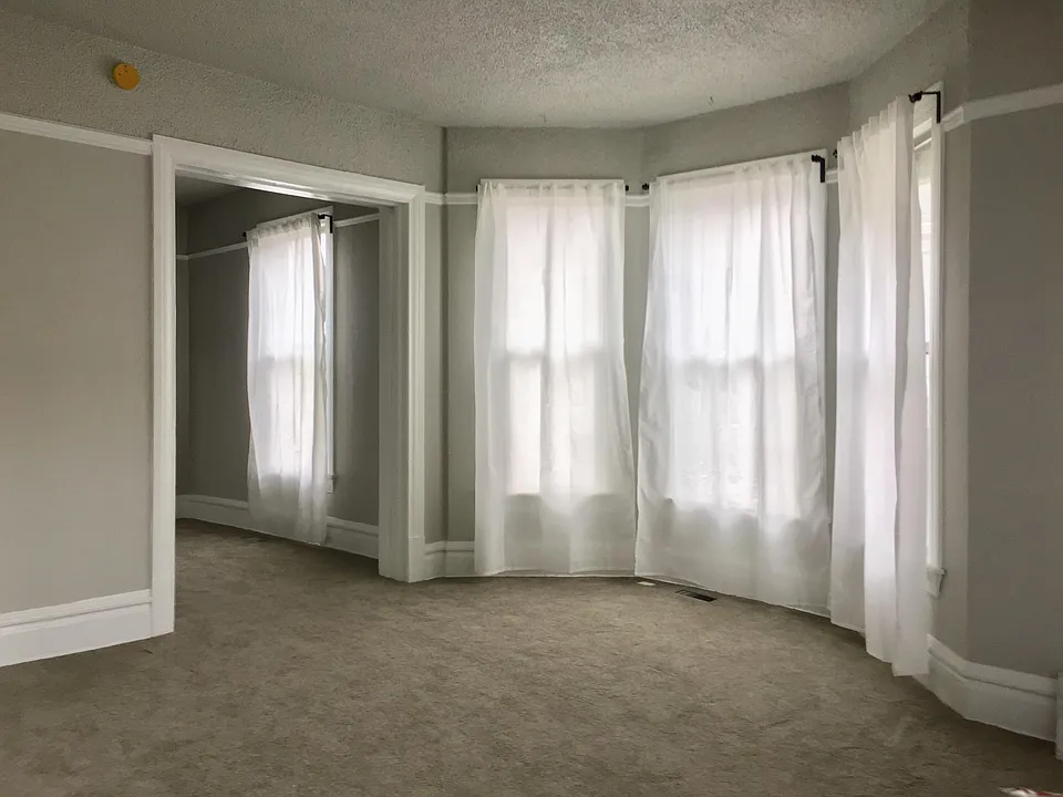 Main living room with bay windows, dining room beyond