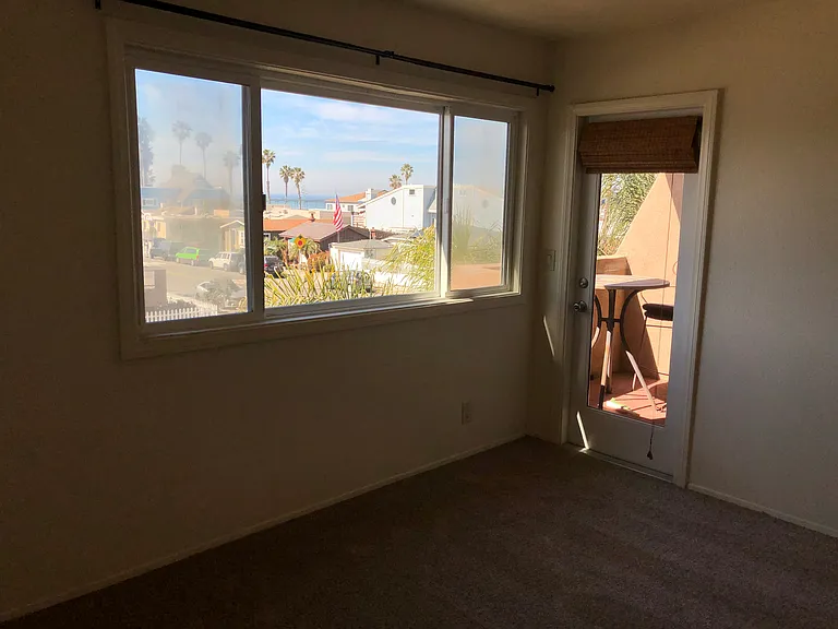 Primary bedroom with door to balcony. Ocean views.