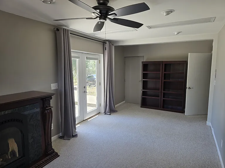 Living room space with adjoining bedroom and door to hallway 23 ft x 10.2 ft.