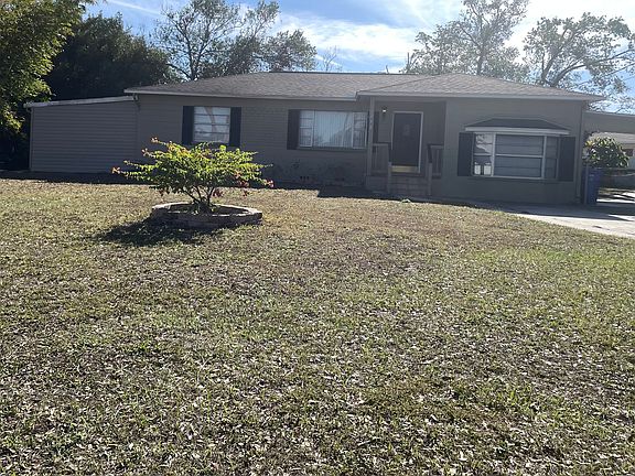 Large enclosed tool shed/workshop on left, carport on right