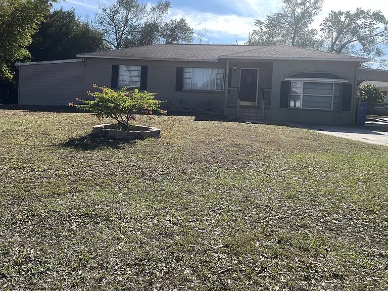 Large enclosed tool shed/workshop on left, carport on right