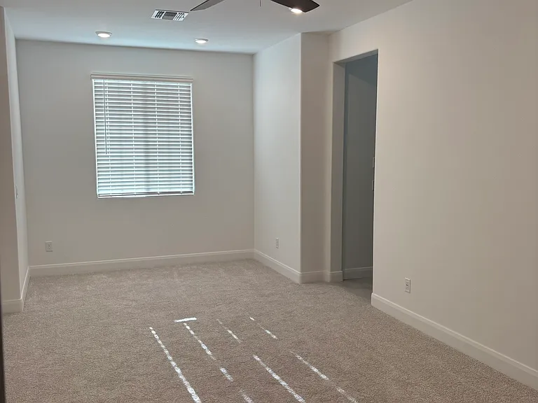 Master bedroom has a ceiling fan and a study or reading nook with views of the White Tank mountains