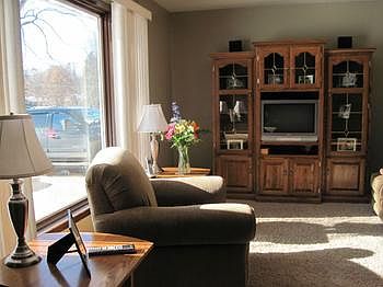 Living room with large picture window, allowing plenty of natural sunlight.