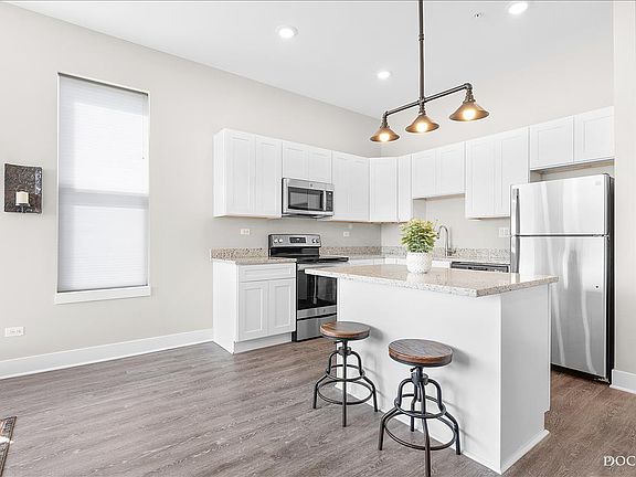 Modern kitchen with granite countertops, soft close cabinets, and stainless steel appliances. Fridge, range/oven, microwave, dishwasher, and garbage disposal included.