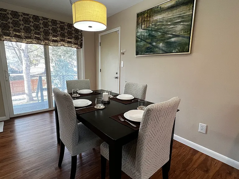 Dining area with seating for four and sliding glass door access to the backyard for easy indoor-outdoor living.
