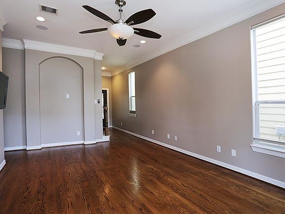 Living room has recessed lighting and crown molding throughout.