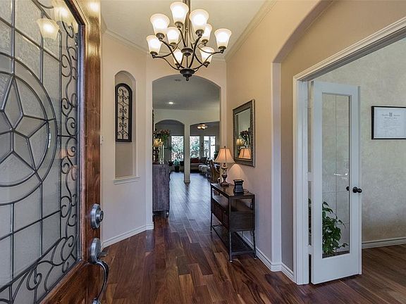 Welcome! Enter through a stately leaded glass door into the inviting foyer, accented by a grand chandelier and art niche. The upgraded Acacia wood floors run from the entry, into the study, and all the way through the kitchen and family room!