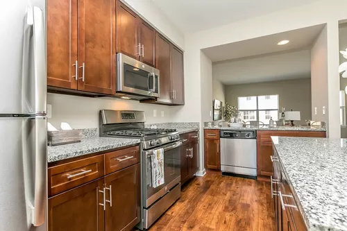 Beautiful, gourmet kitchens featuring granite, stainless steel appliances including gas range - Townes at Pine Orchard
