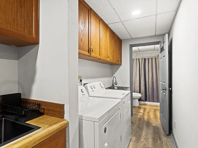 Downstairs laundry room equipped with washer, dryer, and laundry sink.