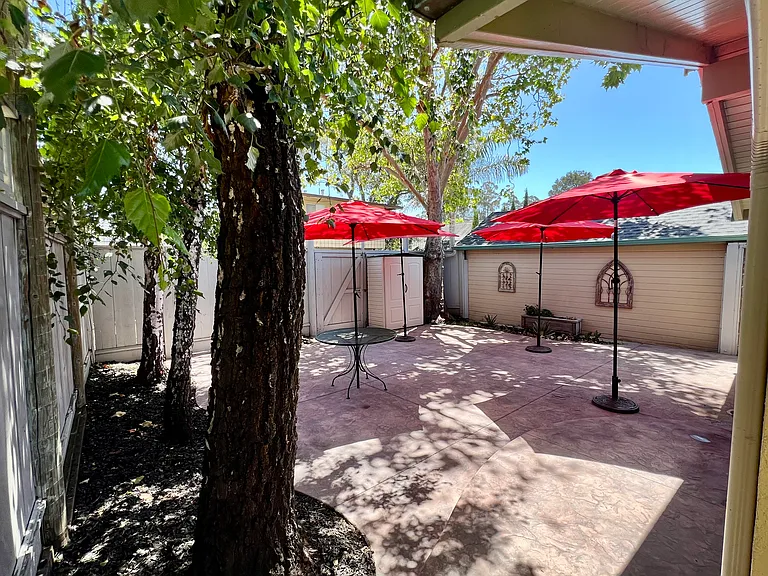Generous, clean hardscape backyard with storage shed. Umbrellas included