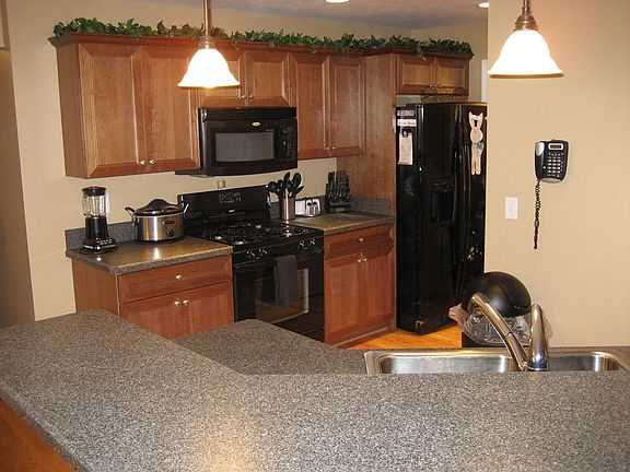 Cherry kitchen with angled breakfast bar and pantry