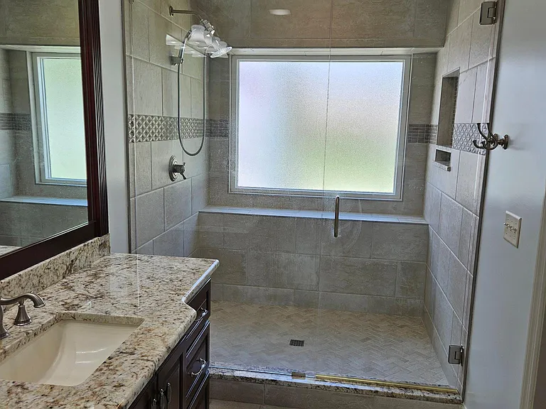 Extra large walk in shower, porcelain tile throughout, and granite countertops.