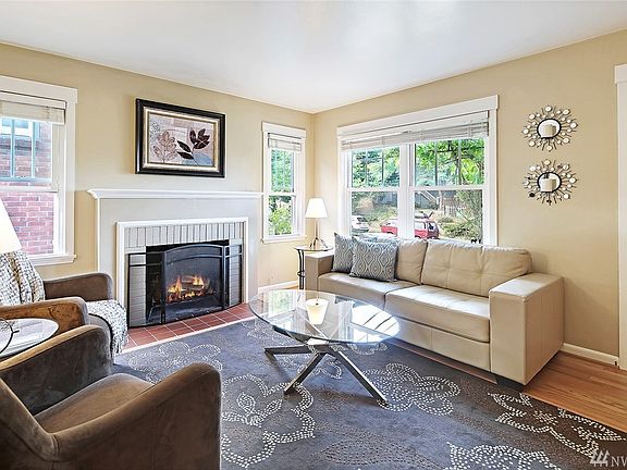 The living room features newly refinished hardwood floors, a cozy wood burning fireplace and large windows allowing an abundance of natural light into the home.