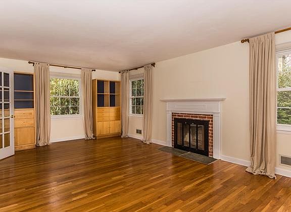 Neutral living rm has a beautiful brick fireplace