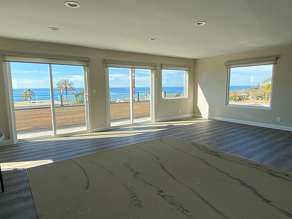 From kitchen during daylight. Look at all that blue ocean. Gorgeous! Beautiful window coverings. Luxury vinyl floors look better in person.