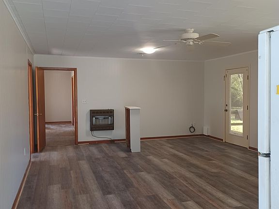 Front entry into Living Room; the stand in the middle of the room goes over the wall furnace near the door