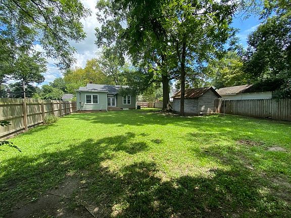 Fenced in backyard, storage shed, and deck