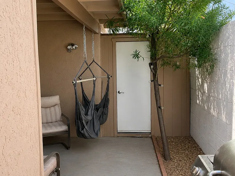 Outside storage area and small backyard covered area over table and chairs