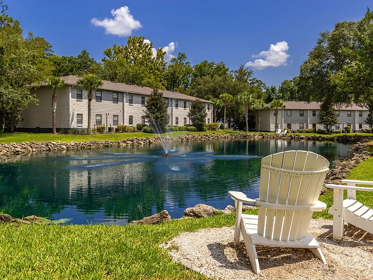 Discover a charming outdoor space with Adirondack chairs for a scenic view of the pond.