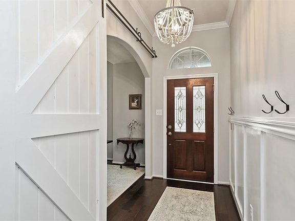 The beautiful entry has wood floors and high ceilings
