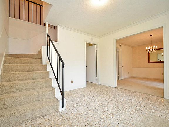 View of the entry way with the stairways to the rooms upstairs, den and dining area on the right sid