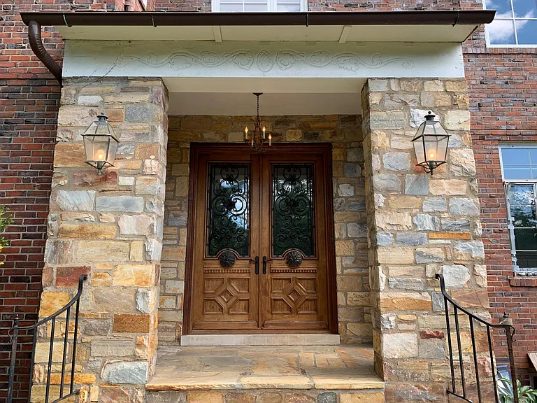 Stone portico with custom doors, wrought iron accents