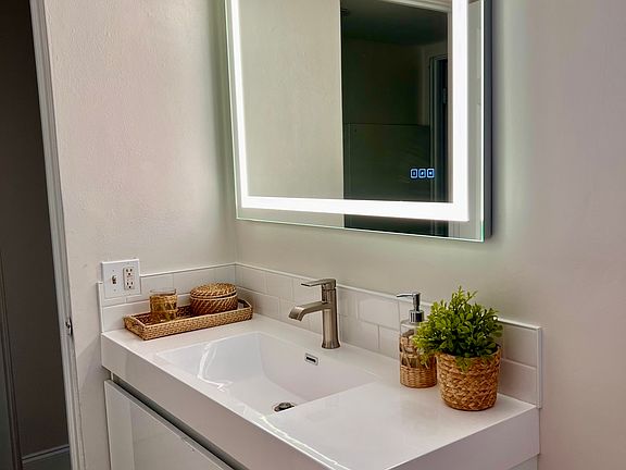 brand are bathroom with floating vanity and Euro toilet, new flooring. New shower with white subway tile as well.