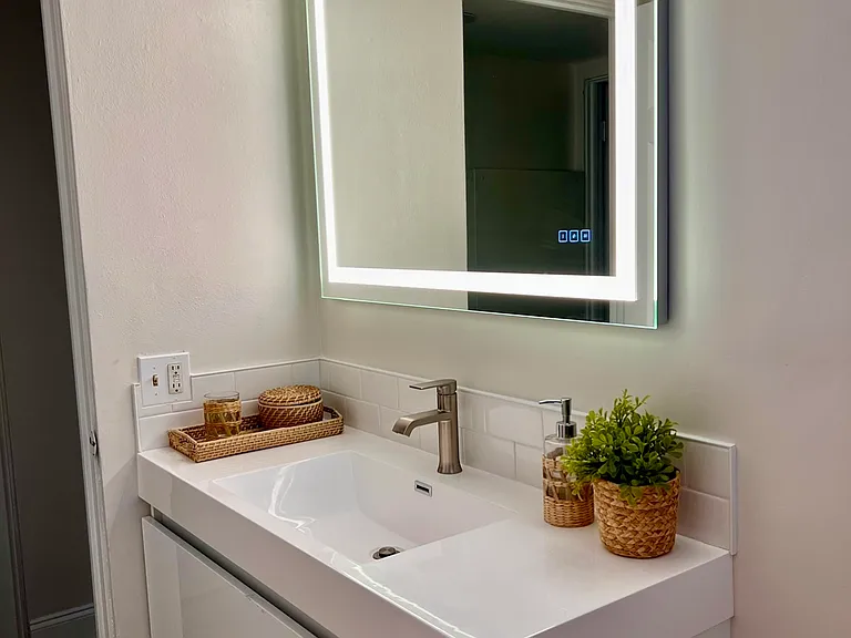 brand new bathroom with floating vanity and Euro toilet, new flooring. New shower with white subway tile.