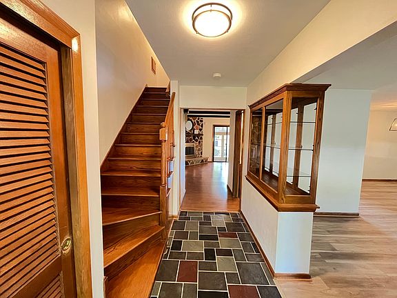 A bright well lit entryway with slate stone, built in, and large coat closet.