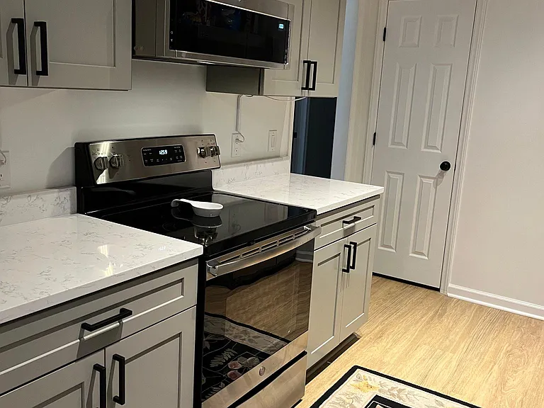 New glass top range and low profile microwave hood provide plenty of room and power to cook. A built-in pantry helps keep things tidy.