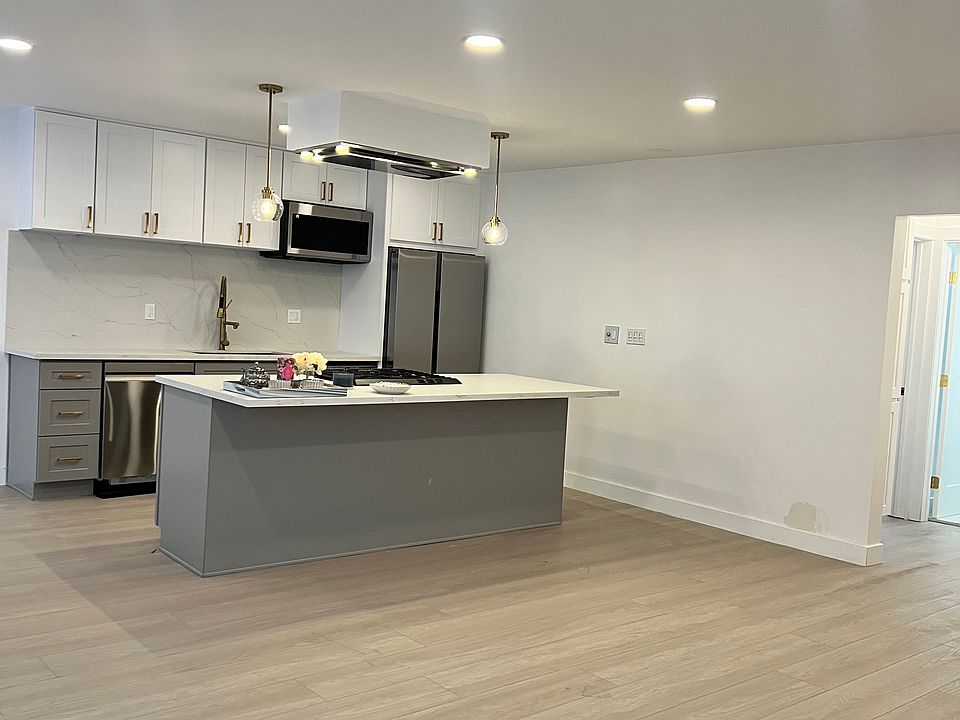 Kitchen with new steanless steal appliances, washer and dryer, dishwasher, refrigerator, microwave.