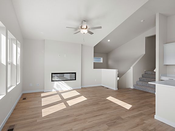 The kitchen has stainless steel appliances and plank flooring.