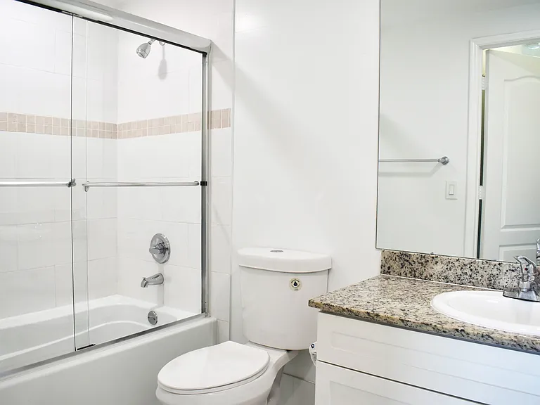 Bathroom with Granite Countertops and Tub with Glass Enclosure