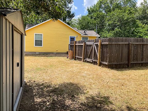 Fenced in back yard, storage shed on left, off-street parking on other side of fence.