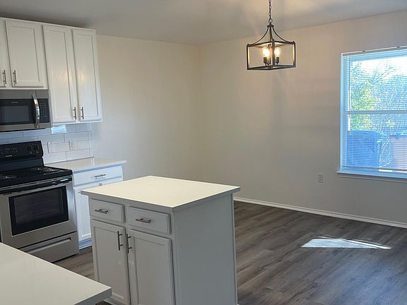 Bright white kitchen with new appliances and large dining area