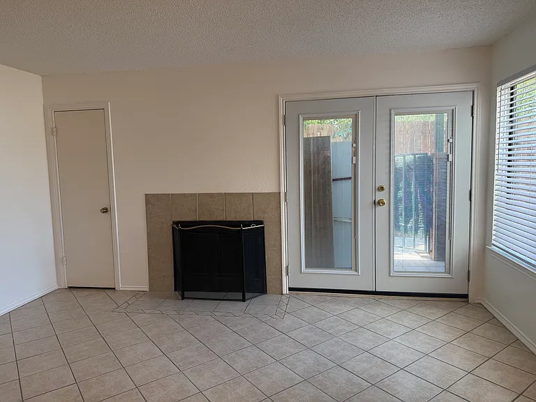 Entryway view with double French doors and enclosed blinds.