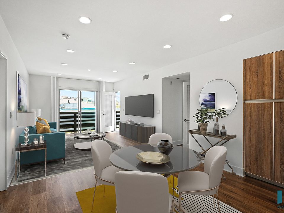 Open-Concept Dining and Living Room with Built-In Cabinet Storage, Recessed Lighting, Vinyl Flooring, and a Patio