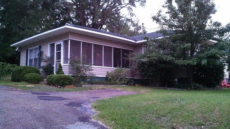 Front view : Tan siding with green shutters