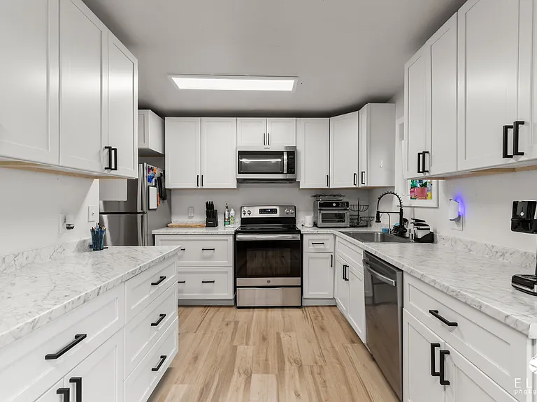 Long view of kitchen. Plenty of counter space and storage for cooking and baking.