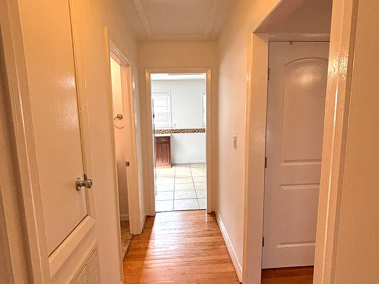 Hallway facing kitchen and laundry room and dining room to the right. Hallway bathroom is on the left