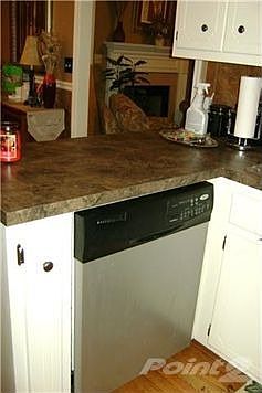 Kitchen with stainless steel dishwasher. View looking into living room area.