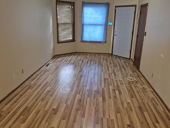 Living room: new flooring. View from dining room through living room to front door.